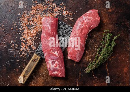 Filet de longe d'agneau non cuit, viande de mouton crue sur le couperet de boucher.Arrière-plan sombre.Vue de dessus Banque D'Images