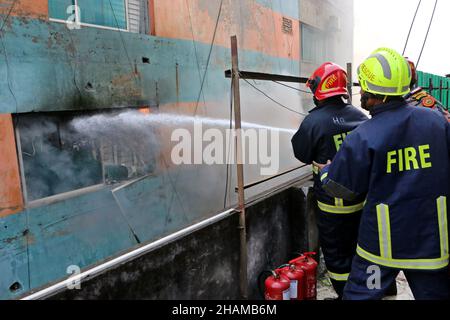 Non exclusif: DHAKA, BANGLADESH - 11 DÉCEMBRE 2021: Le personnel des pompiers travaille pour éteindre un incendie dans un bâtiment comercial dans la zone de Bangla Motor. Banque D'Images