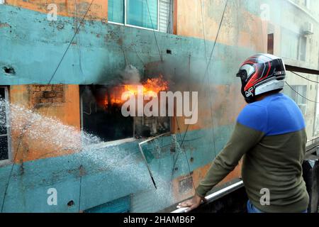 Non exclusif: DHAKA, BANGLADESH - 11 DÉCEMBRE 2021: Le personnel des pompiers travaille pour éteindre un incendie dans un bâtiment comercial dans la zone de Bangla Motor. Banque D'Images