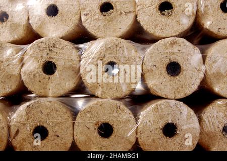 Briquettes rondes en bois enveloppées dans un film plastique Banque D'Images