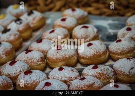 De nombreux beignets pour Hanoukkah, farcis avec des confitures de saveurs diverses, sont en vente au marché de Mahane Yehuda à Jérusalem Banque D'Images