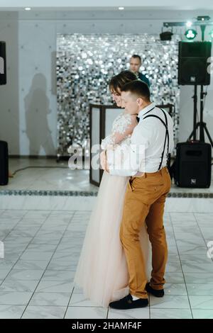 un beau couple de caucasiens vient de se marier et de danser leur première danse.Un couple vient de danser devant ses amis méconnus. Banque D'Images
