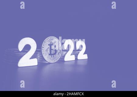 Panneau Bitcoin 2022.Une seule pièce de monnaie Bitcoin à côté des nombres avec un espace de copie pour le texte mis en tons dans la couleur très péri de l'année.Prix, valeur future du concept de prédiction de crypto de BTC. Banque D'Images