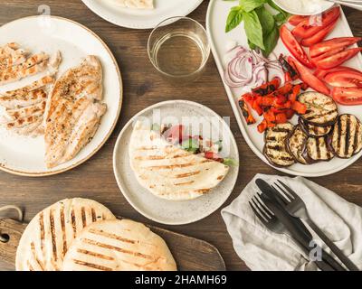 Pita aux légumes grillés, paprika, oignon cru, aubergine, tomate,poulet et basilic avec sauce.Une table est servie pour le dîner. Banque D'Images