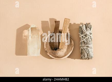 Articles de collection pour le nettoyage spirituel - ensemble de sauge, bâtonnets d'encens palo santo et cristal de quartz sur fond beige.Vue de dessus.Copier l'espace Banque D'Images