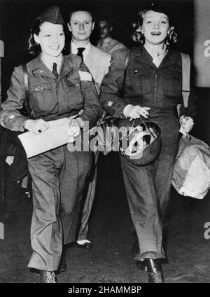 MARLENE DIETRICH et l'actrice LYNN MAYBERRY à leur arrivée à l'aérodrome de LaGuardia à New York en juillet 1945, après une tournée de 11 mois qui a divertis les soldats en Europe avec le mari de Dietrich RUDOLF SIEBER derrière eux Banque D'Images