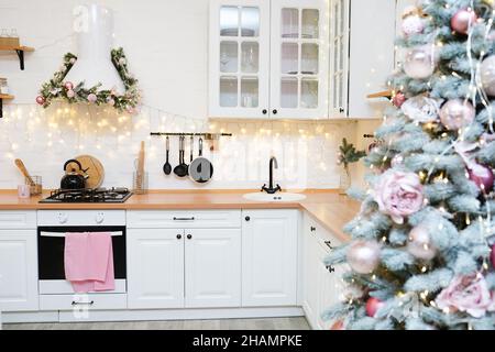 Cuisine intérieure lumineuse avec décoration et lumières de noël roses Banque D'Images