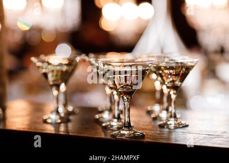 verres à martini devant un fond de bokeh doré.Cocktail de luxe au bar du restaurant avec lumières de nuit floues.Fête de célébration de boissons élégante f Banque D'Images