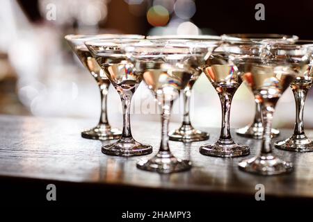 verres à martini devant un fond de bokeh doré.Cocktail de luxe au bar du restaurant avec lumières de nuit floues.Fête de célébration de boissons élégante f Banque D'Images