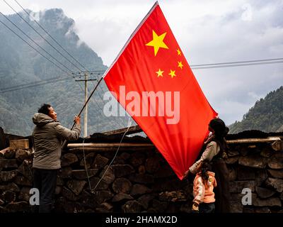 (211214) -- LHASSA, 14 décembre 2021 (Xinhua) -- Nyima (R), un villageois de Sherpa à Zhentang de Xigaze, et sa famille ont un drapeau national chinois devant leur maison le 25 novembre 2021.Située au cœur de l'Himalaya, une petite ville appelée Zhentang dans le comté de Dinggye au Tibet est l'une des colonies de la Sherpa.La ville frontalière a une altitude moyenne de 2 000 mètres.Ces dernières années, de grands changements ont eu lieu à Zhentang.Une série de projets d'infrastructure ont été mis en œuvre.En outre, Zhentang se concentre également sur le développement du commerce transfrontalier, de l'aquaculture, du tourisme et de la proce Banque D'Images