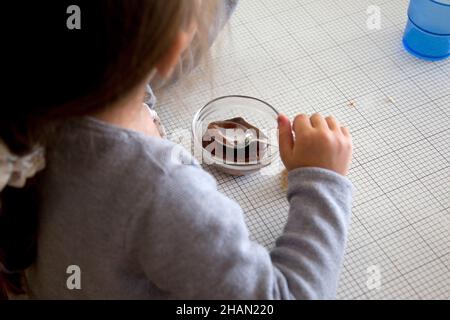 Saint-Martin-de-Queyrieres (Alpes françaises, sud-est de la France) : cantine de l'école primaire.Les enfants déjeunent.Petite fille, élève, manger un cho Banque D'Images