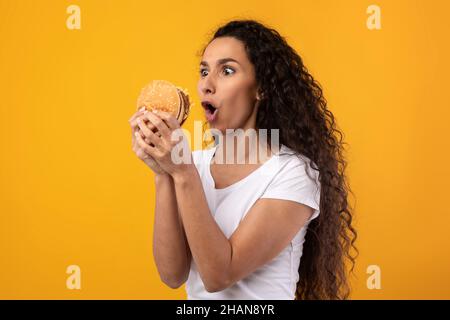 Drôle Latin Lady Holding Burger au Studio Banque D'Images