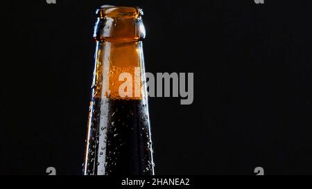 Gros plan d'une main ouvrant une bouteille en verre.Vidéo.Boisson alcoolisée isolée sur fond noir, concept de fête Banque D'Images