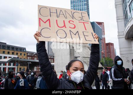 Un manifestant BLM féminin avec changement doit venir étiquette Londres 2020 Banque D'Images