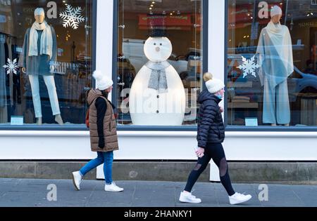 Édimbourg, Écosse, Royaume-Uni.14th décembre 2021.Vues générales des magasins et des bars du centre-ville d'Édimbourg le premier ministre écossais a fait une déclaration au Parlement écossais sur les restrictions sociales visant à contrôler l'augmentation actuelle de la variante Omicron dans les affaires Covid-19 en Écosse.Pic; les membres du public marchent devant la fenêtre du magasin avec exposition de bonhomme de neige.Iain Masterton/Alay Live News. Banque D'Images