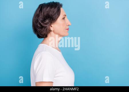 Profil latéral photo portrait femme senior regardant copyspace sérieux strict isolé pastel bleu couleur arrière-plan Banque D'Images