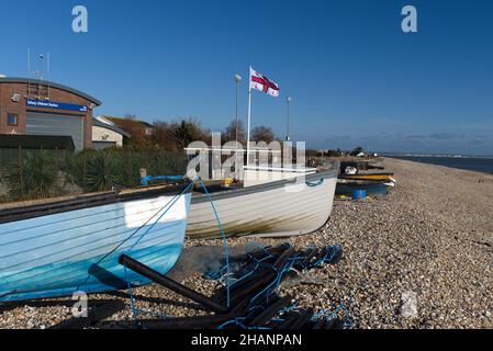 Petits bateaux de pêche en bois sur la plage de galets à Selsey, près de la station de Péniche RNLI Selsey. Banque D'Images