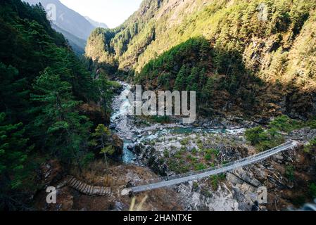 Pont suspendu avec drapeaux de prière bouddhistes sur le circuit Annapurna trek au Népal.Photo de haute qualité Banque D'Images