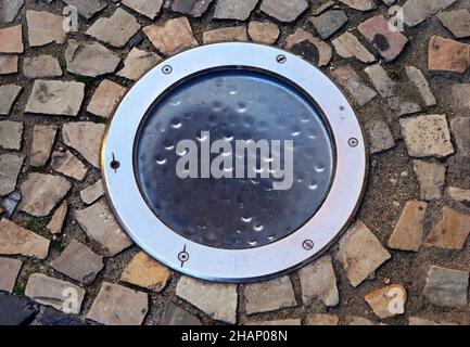 Éclairage au sol sur mosaïque de trottoir Banque D'Images