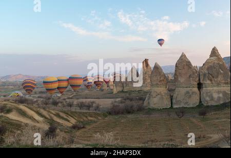 Des dizaines de ballons à air chaud avec des centaines de touristes se levant tôt le matin près de Göreme, Cappadoce, Anatolie centrale, Turquie Banque D'Images