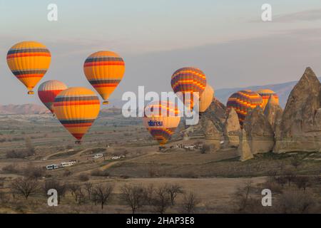 Des dizaines de ballons à air chaud avec des centaines de touristes se levant tôt le matin près de Göreme, Cappadoce, Anatolie centrale, Turquie Banque D'Images