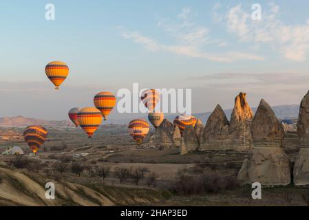 Des dizaines de ballons à air chaud avec des centaines de touristes se levant tôt le matin près de Göreme, Cappadoce, Anatolie centrale, Turquie Banque D'Images