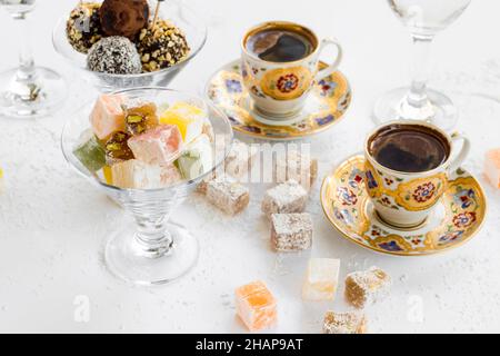 Délicieux délice turc traditionnel Lokum dans un bol de bonbons en verre avec café sur blanc. Image conceptuelle de la fête du sucre Banque D'Images