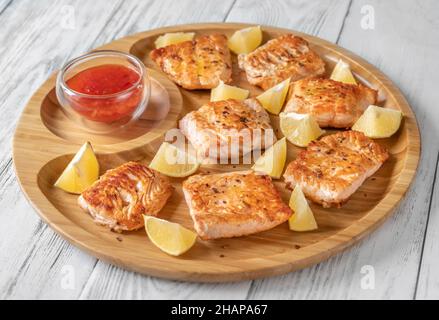 Saumon frit avec sauce sur le plateau de service en bois Banque D'Images