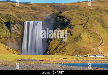 Longue exposition de la célèbre cascade de Skogafoss en Islande à distance avec les randonneurs Banque D'Images