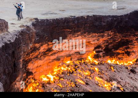 DARVAZA, TURKMÉNISTAN - 19 AVRIL 2018 : couple prenant des selfies au cratère à gaz Darvaza Derweze appelé aussi la porte de l'Enfer au Turkménistan Banque D'Images