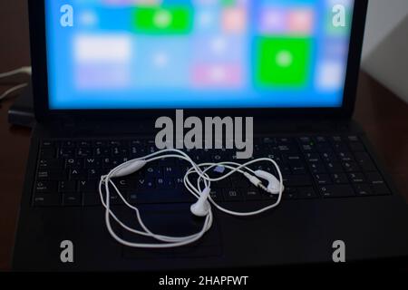 Casque blanc sur le clavier noir de l'ordinateur portable Banque D'Images