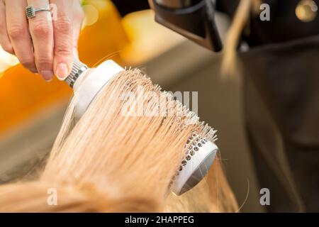 Salon de beauté avec sèche-cheveux et brosse ronde, séchage à la main Banque D'Images