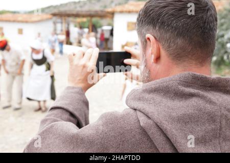 un moine avec un smurtphone prend des photos Banque D'Images