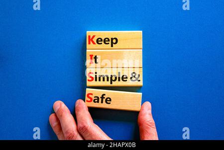 SYMBOLE KISS Keep IT simple and safe.Les mots de concept KISS permettent de garder des blocs de bois simples et sûrs.Belle table bleue, fond bleu.Business et KIS Banque D'Images