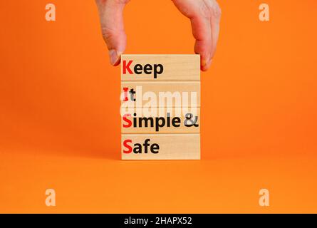 SYMBOLE KISS Keep IT simple and safe.Les mots de concept KISS permettent de garder des blocs de bois simples et sûrs.Belle table orange, fond orange.Entreprise et Banque D'Images