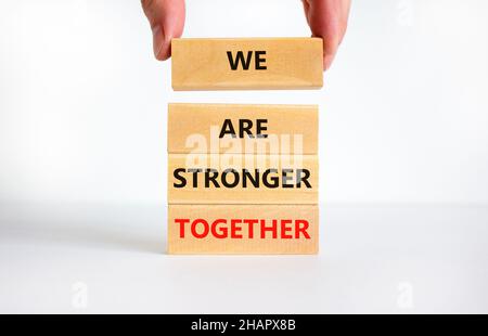 Nous sommes plus forts ensemble symbole.Mots de concept nous sommes plus forts ensemble sur des blocs de bois.Main d'homme d'affaires.Magnifique arrière-plan blanc, espace de copie.Unité commerciale Banque D'Images