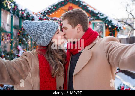 J'aime les jeunes du millénaire qui prennent le selfie tout en embrassant et en célébrant Noël Banque D'Images