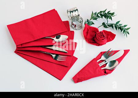 Serviettes en papier rouge de luxe pliées spéciales avec set de couverts et ronds de serviettes sur la surface blanche.concept de Noël ou du nouvel an. Banque D'Images