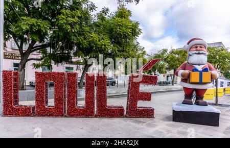 Noël à Loule, Portugal Claus lui-même dans la rue accueillant les visiteurs à Loule, Portugal.Debout à côté d'un grand panneau pour Loule. Banque D'Images