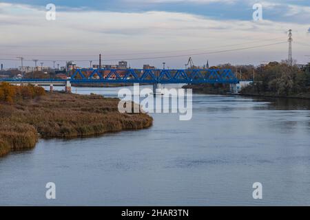 Wroclaw, Pologne - novembre 15 2020 : long pont ferroviaire bleu au-dessus de la rivière Odra par temps nuageux Banque D'Images