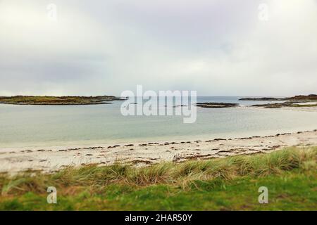 Un canoïste solitaire explore les eaux de l'île STILL bordées de sable blanc sur les plages de Traigh sur la route B8008 près de Morar en Écosse occidentale Banque D'Images