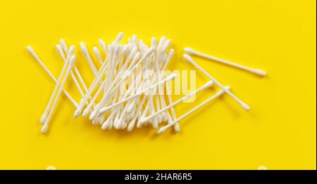 Pile de cotons-tiges ou de cotons-tiges sur un bureau jaune clair, vue du dessus Banque D'Images