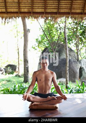 Homme pratiquant Pranayama à Kamalaya, Koh Samui, Thaïlande.L'instructeur de yoga Khun CHACK pratique le pranayama ou la respiration yogique. Banque D'Images