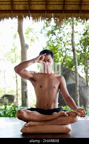 Homme pratiquant Pranayama à Kamalaya, Koh Samui, Thaïlande.L'instructeur de yoga Khun CHACK pratique le pranayama ou la respiration yogique. Banque D'Images