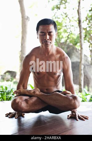 Homme pratiquant Pranayama à Kamalaya, Koh Samui, Thaïlande.L'instructeur de yoga Khun CHACK pratique le pranayama ou la respiration yogique. Banque D'Images