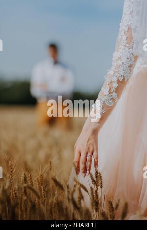 couple de mariage à la mode et heureux au champ de blé par beau temps.Mariée et marié embrassant dans un champ de blé.Jeune beau couple de mariage qui s'embrasse Banque D'Images