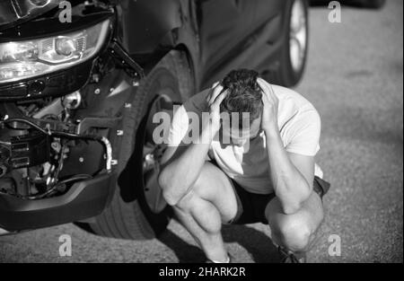 accident de voiture. conducteur frustré après un accident de la route. homme avec auto cassé sur la route. Banque D'Images