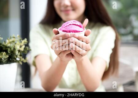 Femme asiatique tenant une tasse de glace à la fraise dans le café Banque D'Images