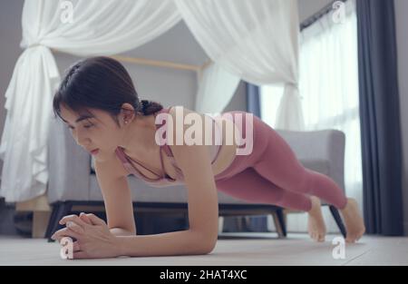 FIT femme faisant de l'exercice de planche, d'entraînement à la maison. Banque D'Images