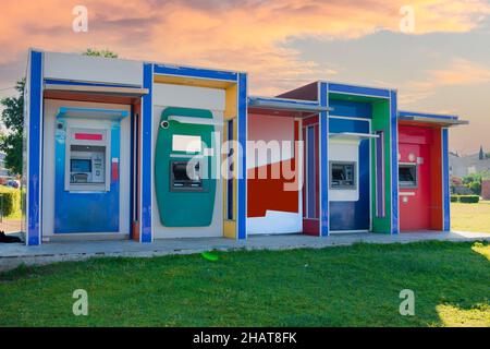 Vue de face d'un guichet automatique dans la rue. Distributeurs automatiques de billets. Colorfull. Mise au point sélective. Ciel de coucher de soleil. Banque D'Images